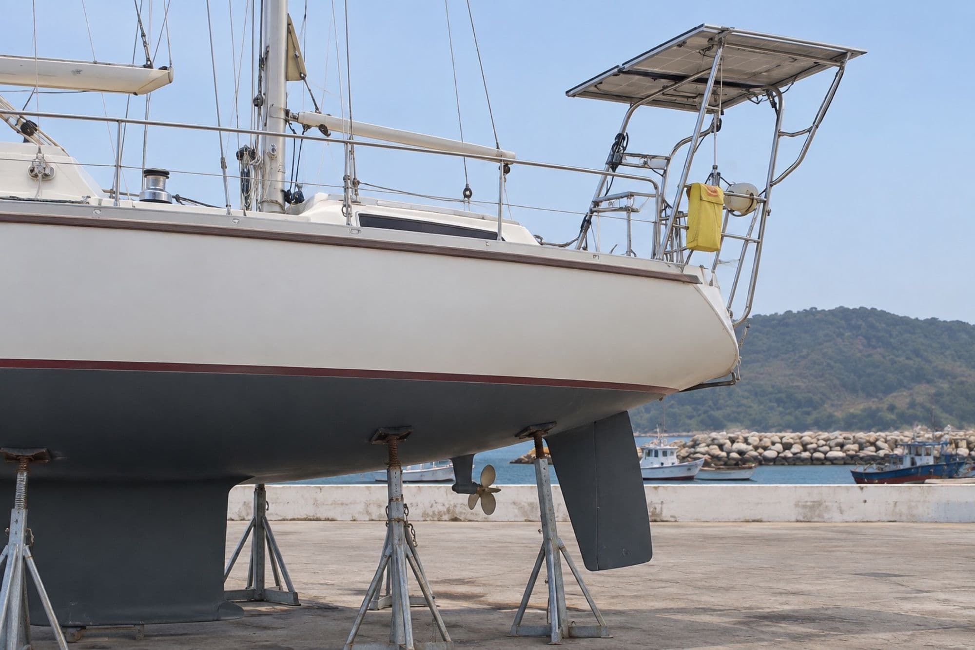 Voilier sous portique de levage avec panneau solaire sur le portique arrière